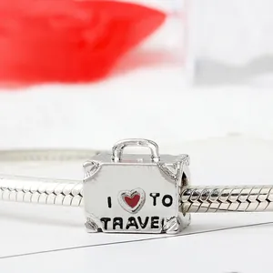 Silver suitcase charm with I Heart To Travel engraving on a snake chain bracelet
