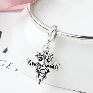 Silver dragon charm with vintage finish on a bracelet over a gift background