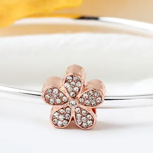 Roségoldener Fünf-Blüten-Charm mit Pavé-Diamanten auf einem polierten Silberarmband
