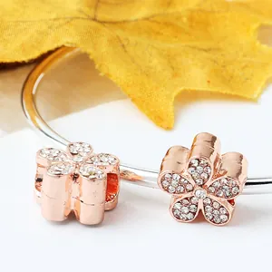 Roségold-Blumen-Charm-Armband mit funkelnden Kristallen auf einem silbernen Reif