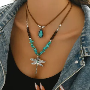 Detail einer Boho-Halskette mit Türkis-Anhänger, Holzperlen und Libellen-Element