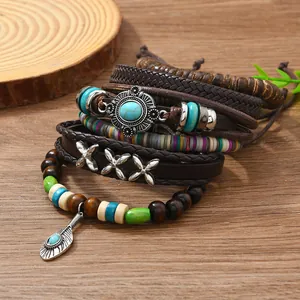 Mehrlagiges Lederarmband-Set mit Türkis-Akzenten auf rustikalem Holz Hintergrund