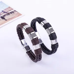 Dettaglio di bracciali multistrato in pelle intrecciata con chiusura magnetica