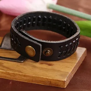 Vista macro del bracciale in pelle nera stile punk con trama a V intrecciata a mano