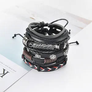 Dettaglio macro di braccialetti in pelle vintage multistrato con ciondolo a piuma