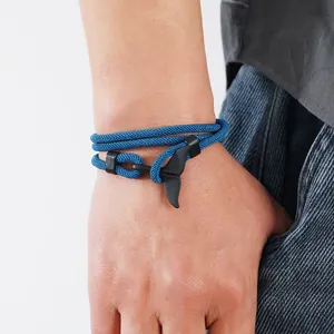 Détail du bracelet tressé bleu paon avec un fermoir crochet noir mat en queue de baleine