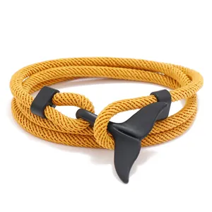 Détail d'un bracelet nautique jaune tissé multicouche avec un fermoir noir mat en queue de baleine