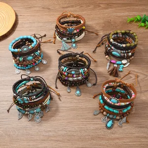 Böhmisches mehrlagiges Lederarmband Set mit Perlen und Vintage Anhängern auf Holz