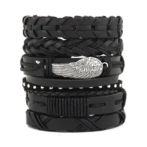 Nahaufnahme schwarzes Punk-Lederarmband-Set mit Silberflügel-Anhänger und Metallnieten