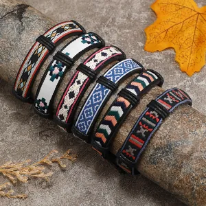 Dettaglio di braccialetti dell'amicizia intrecciati boho su tronchi di legno rustico
