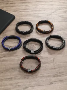 Vista detallada de pulseras de cuentas de piedra natural con cruz sobre fondo madera