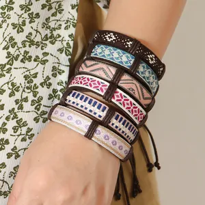Dettaglio di braccialetti dell'amicizia boho a strati con motivi etnici intrecciati