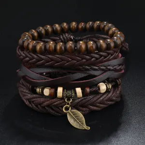 Detailansicht mehrlagiger Lederarmbänder mit Holzperlen und einem metallischen Blattanhänger