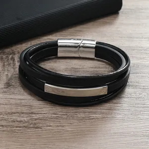 Dettaglio di un bracciale multistrato in pelle nera con chiusura magnetica in argento lucido