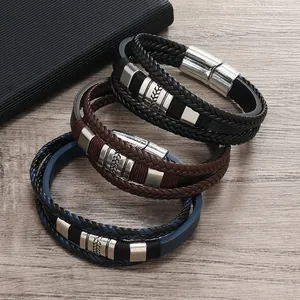 Dettaglio di bracciali in pelle intrecciata a più strati nero, marrone e blu con chiusura