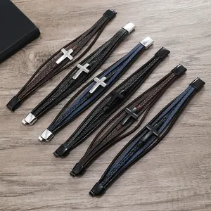 Dettaglio di un set di 6 bracciali in pelle da uomo con croci metalliche e chiusure a scatto