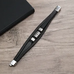 Dettaglio del bracciale multistrato in pelle intrecciata con fibbia in metallo inciso