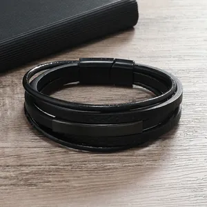 Dettaglio di bracciale multistrato in pelle nera con chiusura magnetica su base in legno