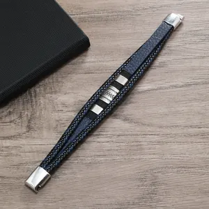 Dettaglio di un bracciale multistrato in pelle intrecciata blu e nero con chiusura magnetica