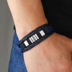 Dettaglio del bracciale multistrato in pelle intrecciata blu e nera con cursori in metallo