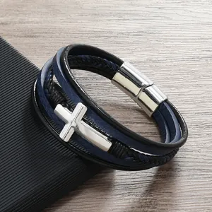 Dettaglio di bracciale in pelle multistrato con croce d'argento e chiusura magnetica