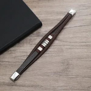 Dettaglio di un bracciale multistrato in pelle da uomo con ciondoli argentati e chiusura magnetica
