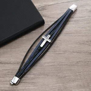 Dettaglio del bracciale in pelle intrecciata multistrato con croce e fibbia magnetica