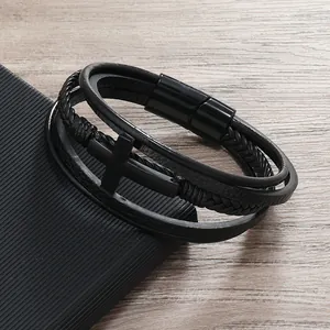 Dettaglio macro del bracciale in pelle nera multistrato con croce e chiusura magnetica