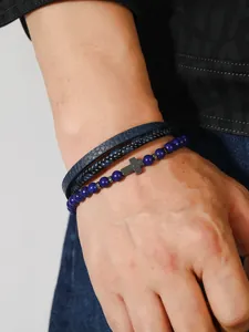 Detalle del conjunto de tres pulseras para hombre con cuentas azules y cruz de metal