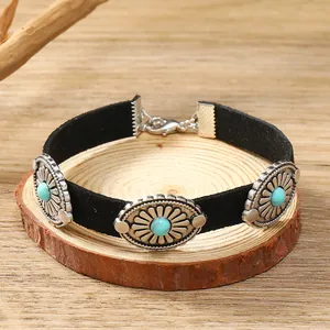 Detail of bohemian black suede choker with turquoise beads and silver floral metal charms
