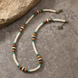 Handmade beaded necklace with turquoise stones and coconut shell on natural stone background