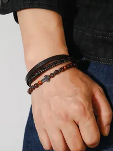 Detalle macro de pulsera para hombre con cuentas ojo de tigre y cuero trenzado con cruz