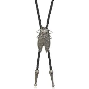 Close-up of vintage cicada bolo tie with carved metal tips and black braided cord
