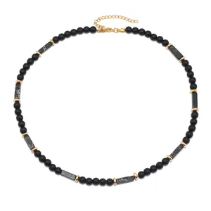 Collana vintage da uomo con pietre nere opache ed elementi dorati su sfondo bianco
