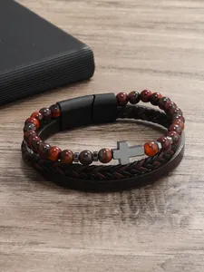 Detalle de pulsera multicapa para hombre con cuentas de ojo de tigre y cruz