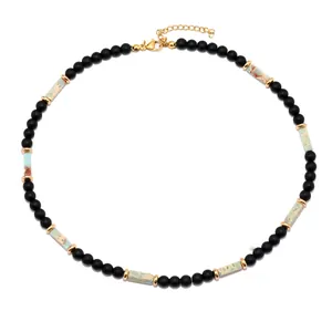 Dettaglio della collana con perle nere, pietre turchesi e chiusura a moschettone dorata