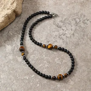 Dettaglio collana con perle di onice opaco, occhio di tigre e chiusura a moschettone