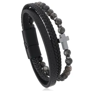 Detalle de pulsera multicapa para hombre de cuero y cuentas de piedra natural con cruz