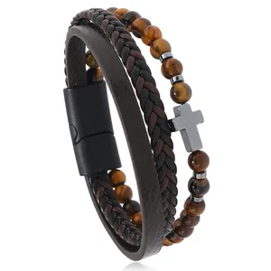 Detalle de pulsera de triple capa para hombre con cuentas ojo de tigre y cruz metal
