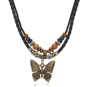 Close-up of bronze butterfly pendant with ethnic wooden beads on multilayer woven necklace