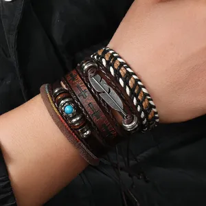Detail eines mehrlagigen Lederarmband-Sets mit Federanhänger und Türkisperle