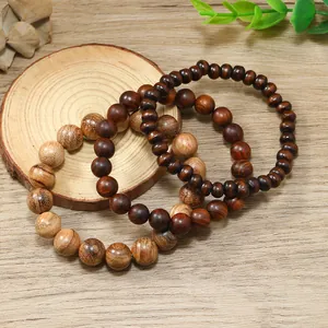 Juego de tres pulseras de cuentas de madera natural en varios tonos sobre fondo de madera
