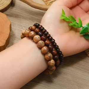 Detalle de un conjunto de tres pulseras de cuentas de madera natural con vetas únicas