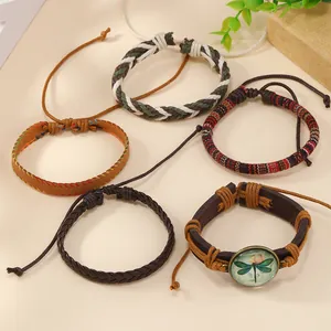 Close-up of five vintage bohemian leather bracelets with dragonfly charm and braided cords