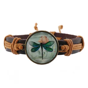 Macro detail of dragonfly charm bracelet featuring woven leather cords and bronze vintage art