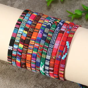 Vue détaillée de bracelets bohèmes tissés en coton aux motifs colorés et textures