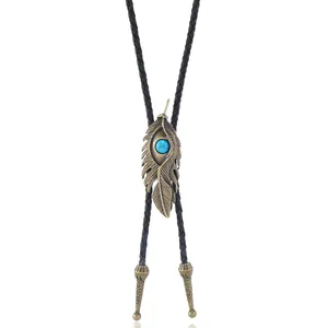 Détail du pendentif bolo tie plume en bronze vintage avec turquoise et cordon en cuir tressé