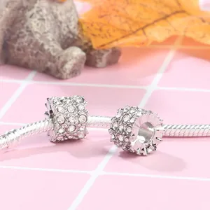 Macro detail of silver alloy charms with clear crystals on a snake chain bracelet
