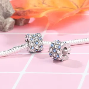 Macro shot of blue and white sparkling charms on a silver snake chain bracelet