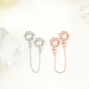 Detailansicht hohler Blumen-Schmuckanhänger mit Kristallen in Silber und Roségold